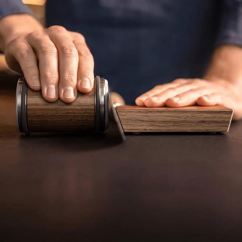 A chef's knife held upright by the strong magnet of the Honewood angle base